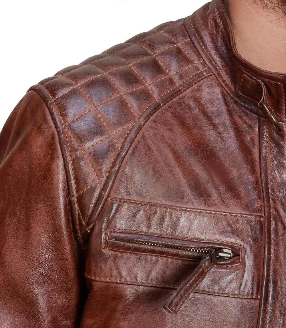 Close-up of a brown leather jacket with quilted shoulder design.