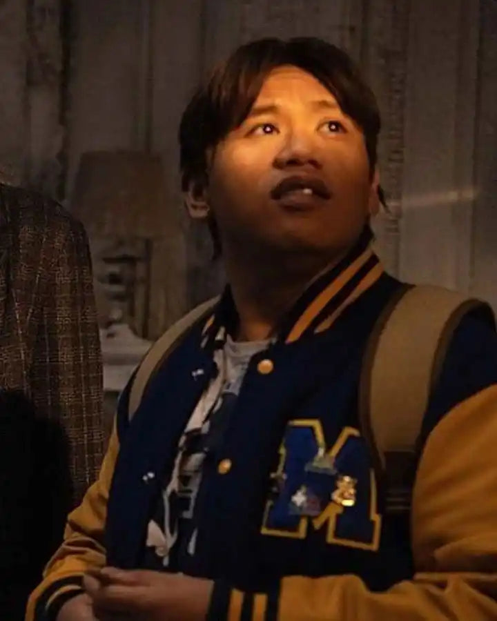 Person wearing a varsity jacket with a letter 'M' on a dark background